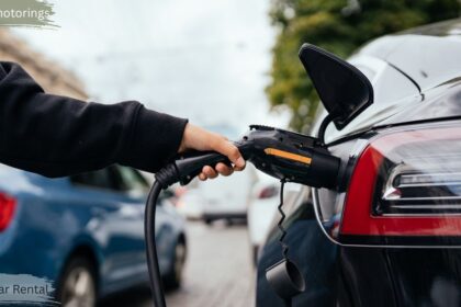 Person charging an electric rental car at a public EV charging station, illustrating electric car rental and sustainable transportation in Canada.