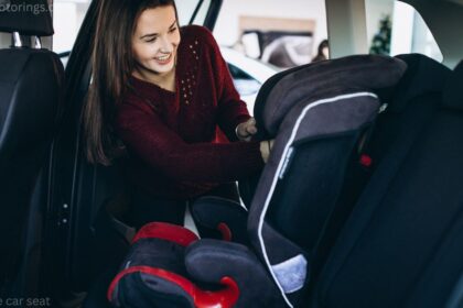 Canadian parent buckling toddler into a convertible car seat inside a family vehicle.