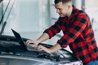 Mechanic checking car battery cost and voltage on a vehicle in a Canadian auto shop during winter.